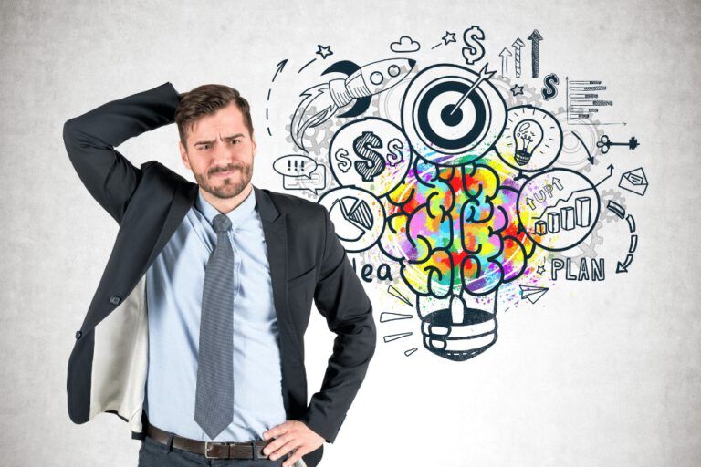 A businessman standing in front of a light bulb with ideas drawn on it.